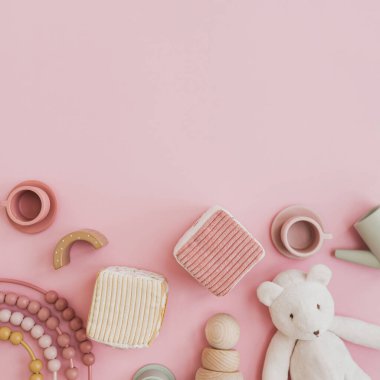 Şık İskandinav bebek oyuncakları. Pastel pembe arka planda ve boş fotokopi alanı var. Oyun ve eğitim için bebek eşyaları. Düz yatış, üst görünüm