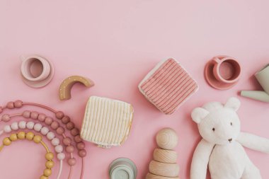 Boş kopya alanı ile düz yatıyordu. Pembe arka planda bebek eşyaları. İskandinav doğal tahta oyuncakları