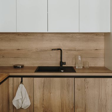 Modern yeni apartman iç tasarımı. Beyaz ve ahşap mobilyalar, çatal bıçak ve musluk. Kiralık daireler