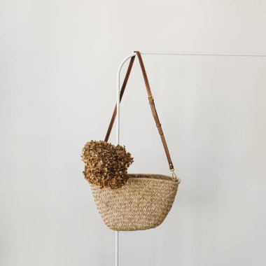 Zarif moda aksesuarı. Askıda kurutulmuş ortanca çiçekli saman el çantası. Moda günlüğü, kopyalama alanı olan sosyal medya şablonu