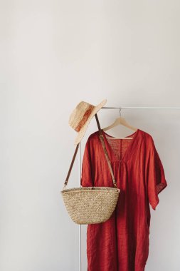 Şık moda kıyafetleri ve aksesuarlar. Kırmızı elbise, hasır şapka, askıda saman çanta. Moda günlüğü, kopyalama alanı olan sosyal medya şablonu