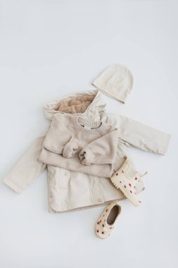 Bebek için tatlı pastel elbiseler ve aksesuarlar. Sıcak giysi: kazak, yağmurluk, çizme, şapka. Estetik bebek moda mağazası, alışveriş konsepti
