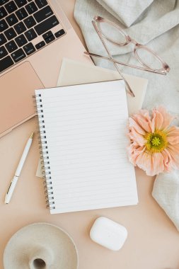 Kopya alanı olan boş defter sayfası. Konforlu ofis çalışma alanı. Evde çalış. Dizüstü bilgisayar, defter, haşhaş çiçeği, kulaklık, bardaklar, masa örtüsü. Düz yatış, üst görünüm