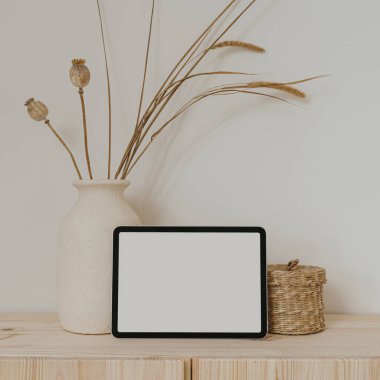Boş fotokopi alanı olan tablet ekranı, kurutulmuş çimenli kil saksı, rattan tabut. Parlak estetik sosyal medya markası, çevrimiçi alışveriş şablonu