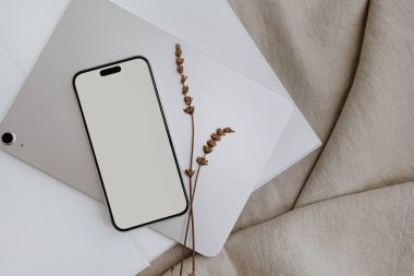 Mobil telefon ekranı, boş fotokopi alanı, tablet, kurutulmuş çimenler ve nötr bej kumaş kumaş. Parlak estetik sosyal medya markası, nötr bej renkli online alışveriş şablonu