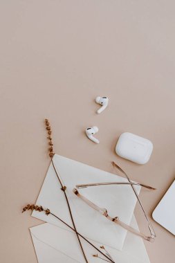 Ofis masası çalışma masası. Kulaklıklar, gözlükler, bej masasında kurumuş çimenler. Ev konseptine göre biçimlendirilmiş ev işi