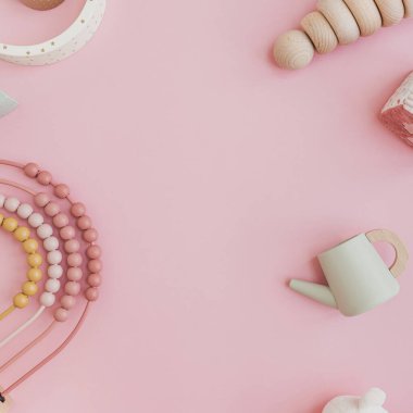 Şık İskandinav bebek oyuncakları. Pastel pembe arka planda ve boş fotokopi alanı var. Oyun ve eğitim için bebek eşyaları. Düz yatış, üst görünüm