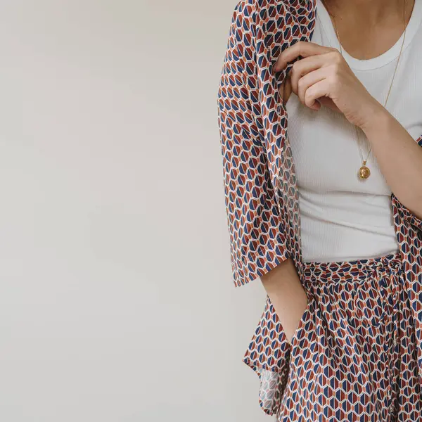 Beyaz arka planda mor ipek süslemeli genç ve güzel bir kadın. Moda konsepti