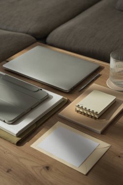 Ev ofisinin çalışma alanı dizüstü bilgisayarı, bir bardak su, tablet, güneş ışığı gölgesinde kırtasiye malzemesi. Estetik lüks bohem kadın patron iş hayatı konsepti