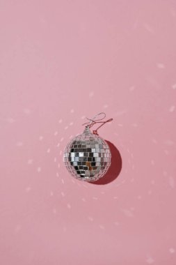 Pembe arka planda aynalı ışıklar ve fotokopi alanı olan estetik parlayan disko topu. Basit bir tatil partisi olayı. Parlak retro disko topu