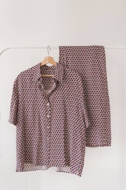 Beyaz arkaplanda asılı mor pijamalar