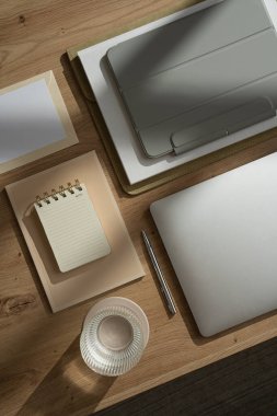 Estetik minimalist ofis çalışma masası. Dizüstü bilgisayar, tablet, defter, bir bardak su, fotokopi alanı olan boş kağıt. Flatlay, üst görünüm ev işi, iş konsepti