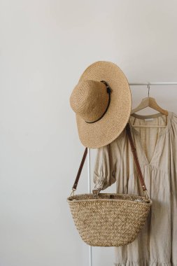 Şık moda kıyafetleri ve aksesuarlar. Bej keten elbise, hasır şapka, askıda saman el çantası. Moda günlüğü, kopyalama alanı olan sosyal medya şablonu