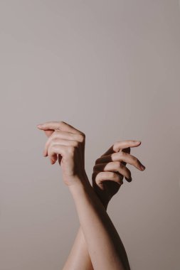 Yumuşak kremsi bej arka planda kadın elleri. Yakın görünüm