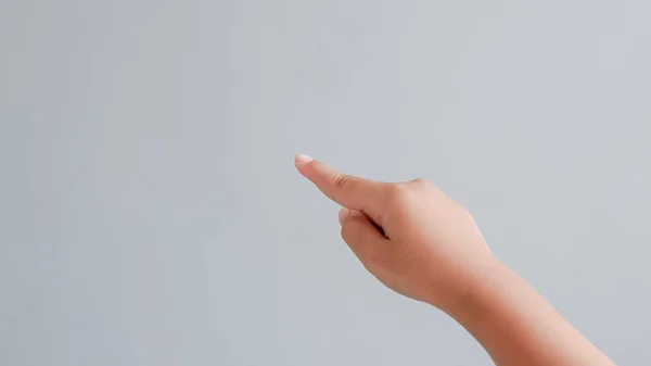 show forward, point, press with index finger hand gesture on grey background.