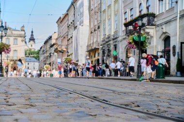 Tramvay için raylı eski bir yol Kalabalık bir sokak Bulanık arka planda