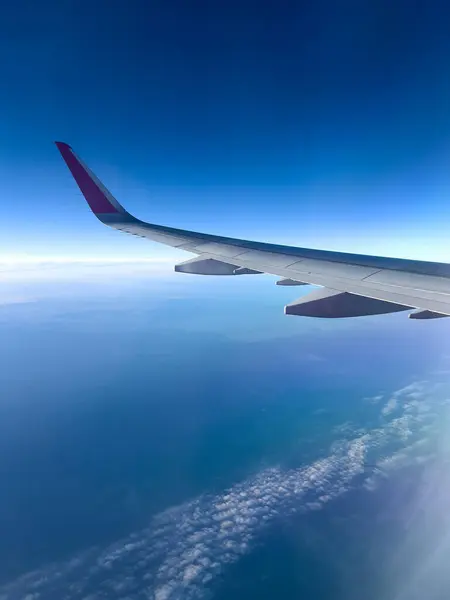 Güneş doğduktan sonra okyanus üzerinde uçmak, uçağın bir kanadı, bulutsuz, mobil fotoğraf.