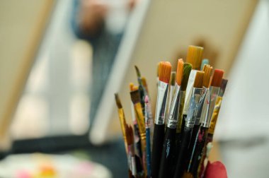 Arkasında sehpa olan boya fırçaları.