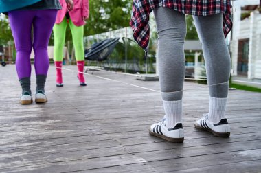 Markalı elbiseli kadın bacakları lastik bir bandın üzerinde zıplama oyunu oynuyor.