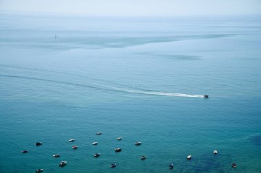 Praia do Monte Branco Portekiz 'de demirli teknelerin yanından geçen yat. 2024. Yüksek kalite fotoğraf