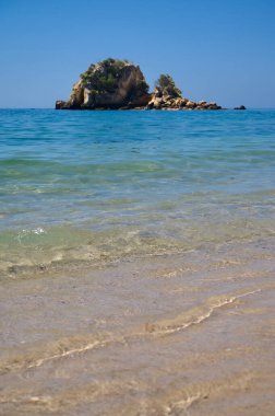 Okyanusun ortasındaki küçük Anixa adası ve Portekiz plajı, 2024. Dikey fotoğraf