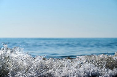 Dalgalar yavaşça sahile doğru süzülüyor, parlak güneş ışığında parlıyor. Huzurlu bir sahne, okyanus kıyısında sakin bir günün özünü yakalar, rahatlamayı davet eder..