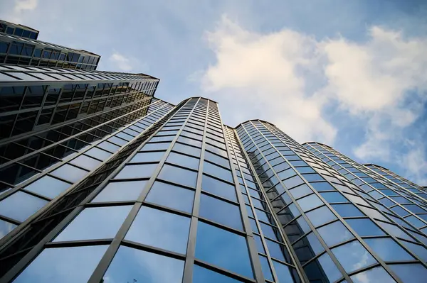 Cam paneller, bulutlarla dolu gökyüzünü görkemli bir şekilde yansıtıyor. Işık oyunu çarpıcı bir görsel ahenk yaratır, kentsel tasarım, zarafet ve yenilik sergiler..