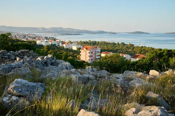 Resmedilmeye değer bir sahil köyüne bakan bu sakin manzara, sakin sulara ve adalara karşı kayalık oluşumların ve yumuşak yeşilliğin bir karışımını sabah ışığı altında sergiliyor.. 