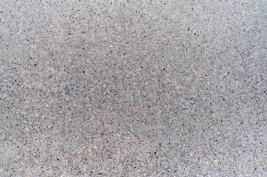 Pürüzsüz gri beton yüzeyin yakın plan görüntüsü ince dokusunu ve tasarım için ideal tek renk rengini gözler önüne seriyor..