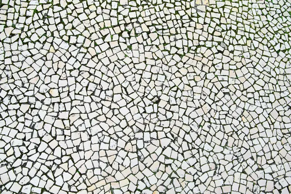 Beyaz taşların karmaşık düzenlenmesi, güneş gören bir meydanda mozaik bir etki yaratarak sanatsal ayrıntıları vurguluyor..