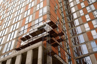 İşçiler kalabalık bir şehirde yeni bir bina inşa etmekle meşguller..