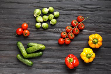 Tomatoes, cucumbers, peppers, Brussels sprouts on a wooden background top view. Mix of healthy vegetables. Raw summer vegetables. A symbol of proper, wholesome nutrition.
