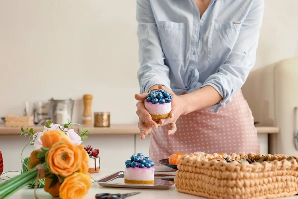 Handmade soap. Home made soap look like cake with berries on light background. Natural homemade cosmetics and handmade soaps concept. The girl is holding a homemade muffin in her hands