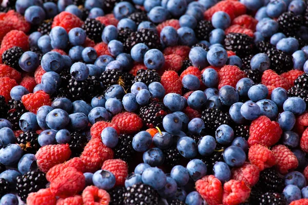 Background from healthy fruits. Blueberries, blackberries and raspberries. Flat lay. Vitamins in natural products. Berries.