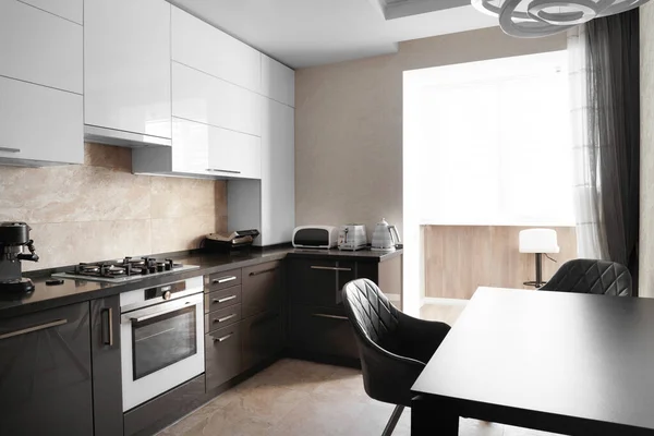 The kitchen in the apartment. The design of the kitchen room. Gray kitchen interior with white cabinets. Built-in oven in the interior of the kitchen.. Kitchen interier.