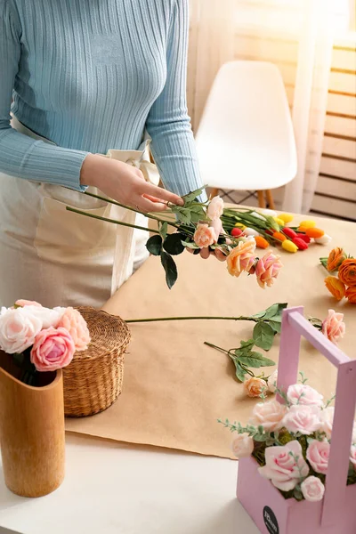 Girl florist makes a bouquet. Bouquet of soap close-up in the hands of a florist. Roses and tulips in the hands of a girl in a flower shop