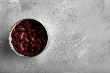 Kavanozda konserve fasulye. Yapısal gri arka plan manzaralı. Metni olan sağlıklı yiyecekler.