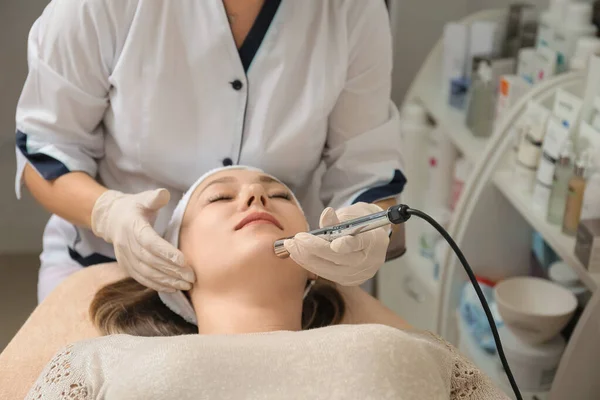 Face treatments. The concept of maintaining health, youth and beauty. Modern cosmetology, beautician tools, hands with gloves. Hardware cosmetology. Face lifting. Anti-aging cosmetic procedures.