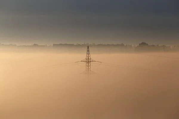 Sabahın Sisinde Şehrin Arka Planına Karşı Yüksek Voltaj Direği Şehirdeki — Stok fotoğraf