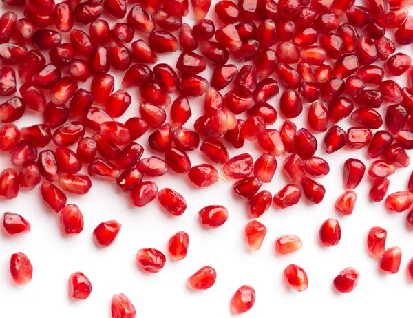 Red grains of a ripe pomegranate are neatly laid out on a white background top view. Pomegranate grains on isolated. Background of pomegranate seeds.