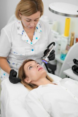 Yüz ve vücut bakımı. Sağlık, gençlik ve güzelliği koruma kavramı. Yüz maskeleri, modern kozmetoloji, güzellik aletleri, eldivenli eller. Güzellik teknikleri.