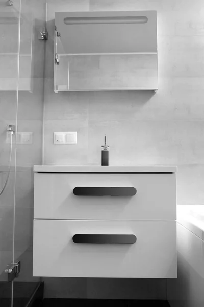 モダンなバスルーム キャビネットと引き出し付きの白い洗面台 クロム蛇口 大きな照明ミラー ガラスシャワーキャビンのインテリアの一部 浴室のデザイン — ストック写真