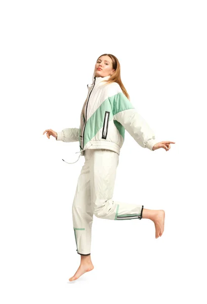 一个穿着时髦轻便运动服的女孩赤脚站在白色的背景上 做着服装广告 穿上街头风格的服装 穿着舒适时髦的休闲装 — 图库照片
