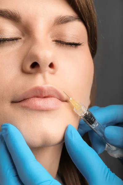 Facial treatments. The concept of maintaining health, youth and beauty. Modern cosmetology, beautician tools, gloved hands. beauty techniques. beauty injections. Lip augmentation with fillers.