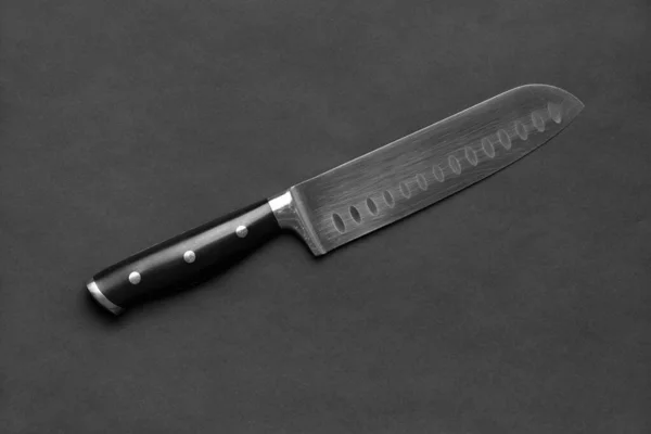黒い背景に黒いハンドルのキッチンナイフ 暗い背景に大きなナイフ 台所用品だ 刃幅の広いナイフ — ストック写真