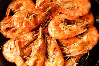 Siyah bir tabakta karides kızartması. Yakın plan. Koyu arkaplanda karides ızgarası.