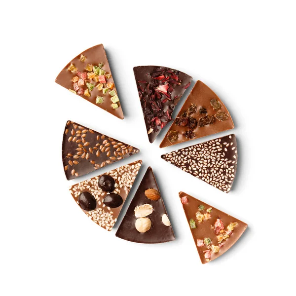 Chocolate pizza made of black and milk chocolate with candied fruits, nuts, raisins on a white background top view. Chocolate dessert in the form of pizza with different toppings.