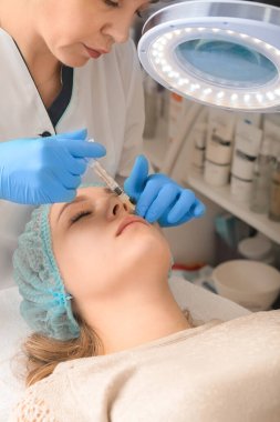 Facial treatments. The concept of maintaining health, youth and beauty. Modern cosmetology, beautician tools, gloved hands. beauty techniques. beauty injections. Lip augmentation with fillers.