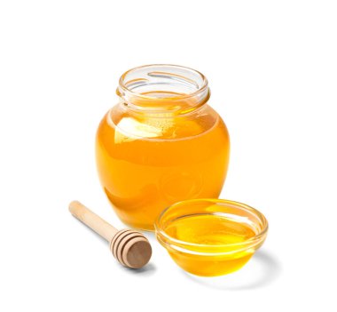Organic honey in a glass jar and a transparent bowl, wooden dipper on a white background. Spoon for honey and fresh honey in an open jars on isolation close-up. Healthy products.