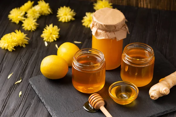 Honey Jars Dipper Lemon Ginger Black Stone Plate Wooden Background — Stock Photo, Image